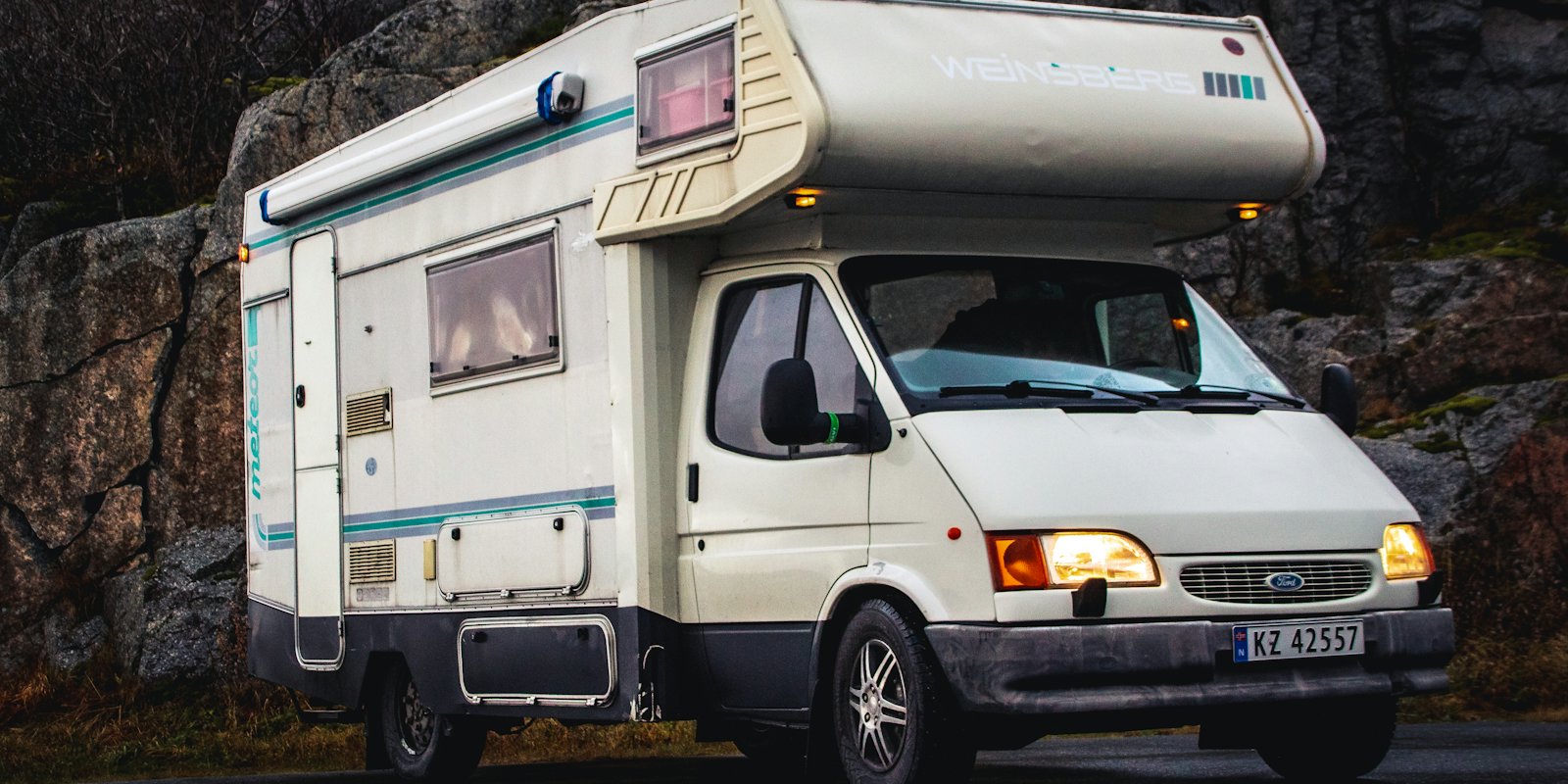 A Class C motorhome parked on a gravel road