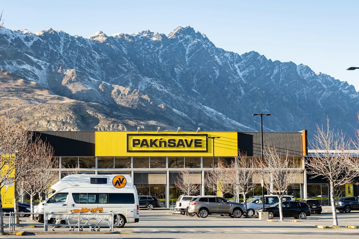 Campervans in a car park below mountains in Queenstown