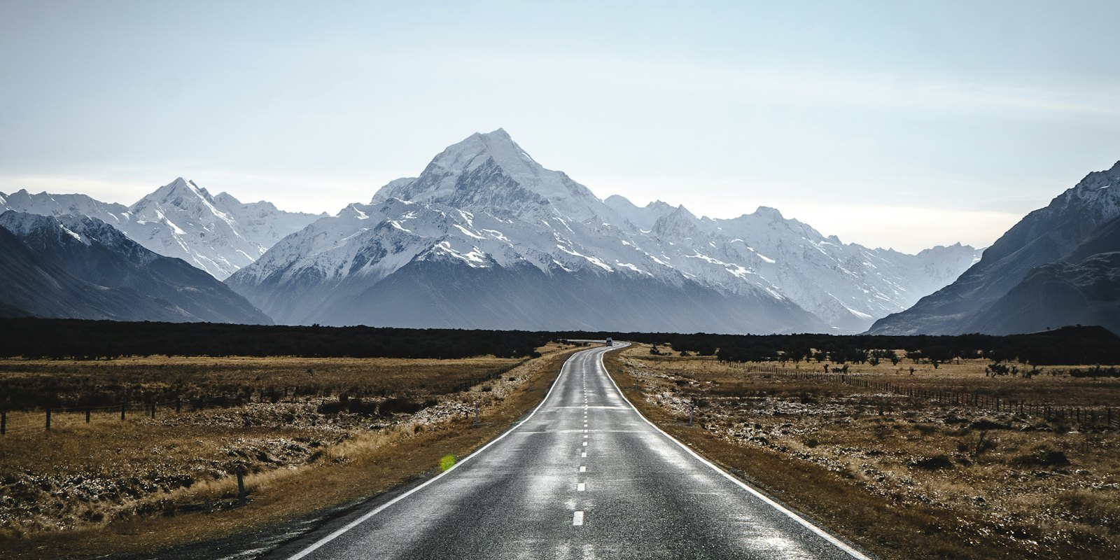 A straight road leading toward the snow-capped Aoraki/Mount Cook range, New Zealand