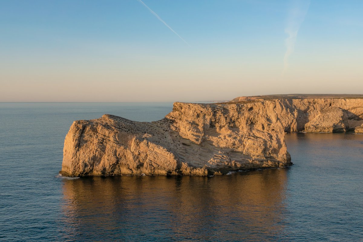A flat-topped headland above the sea at sunset near Sagres