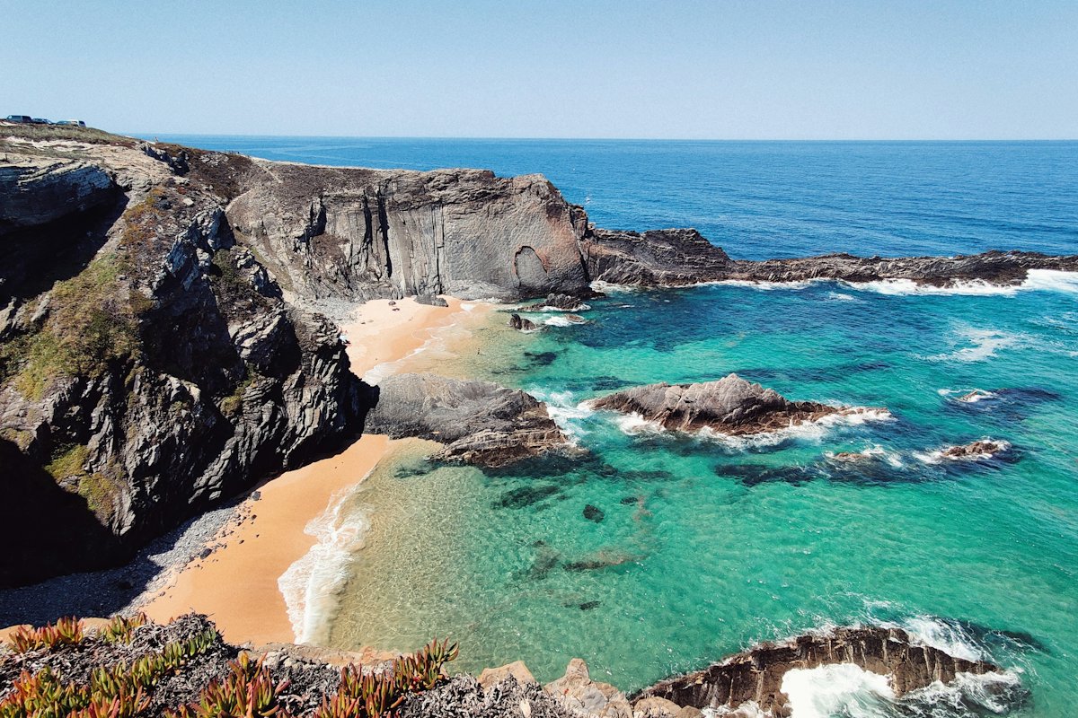 A small sandy cove between rocky cliffs on the Portuguese coast