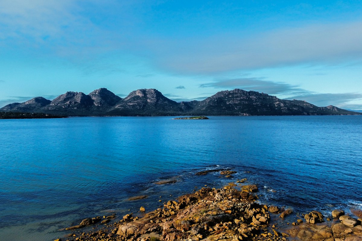 The granite peaks of The Hazards across blue water in Freycinet National Park